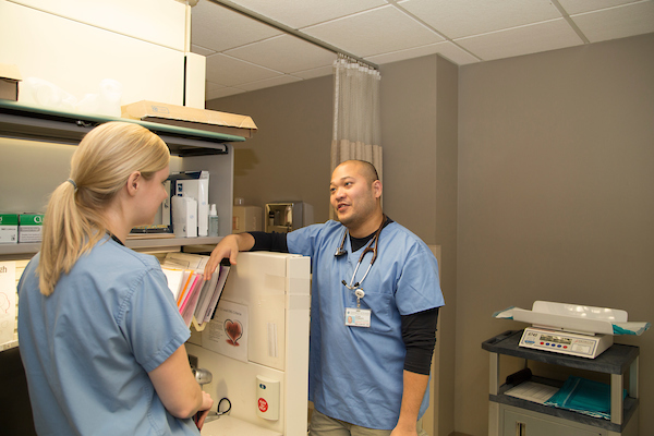 Image of two clinicians in blue scrubs talking